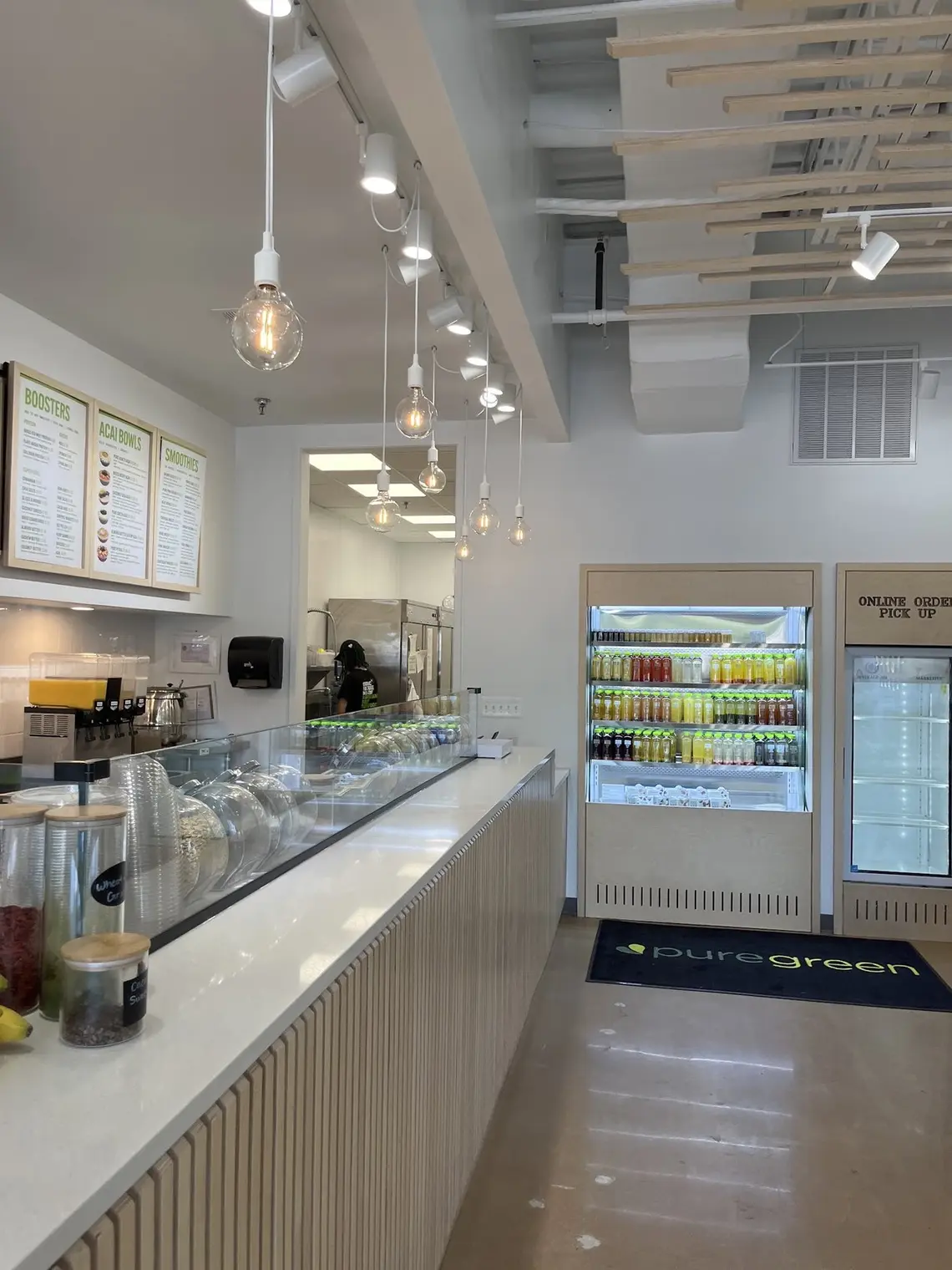 The order counter, juice fridge and menu boards inside Pure Green Columbia