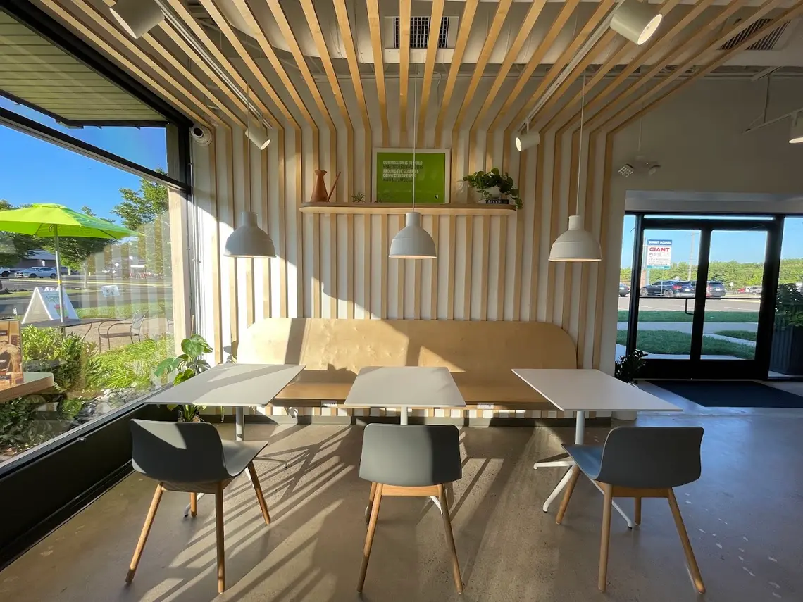 Tables and bench seating in the sunlit room at Pure Green Newtown