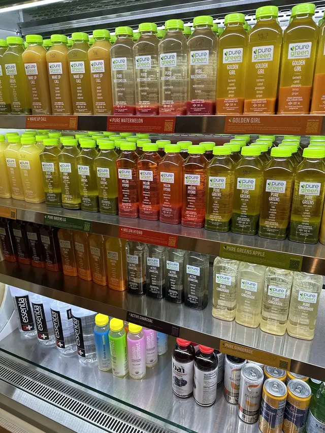 Rows of cold-pressed juice in the fridge at Pure Green Charles Village