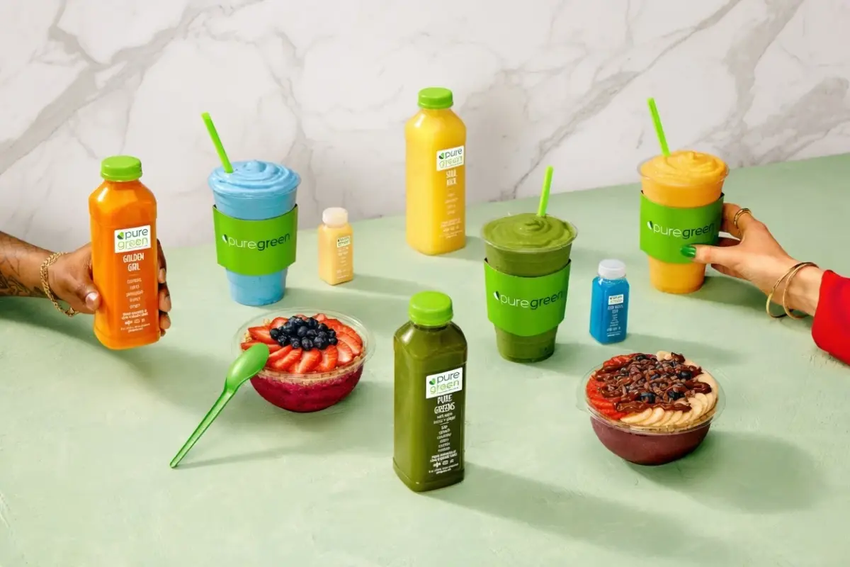 Pure Green smoothies, juices, bowls and shots arranged on a counter.