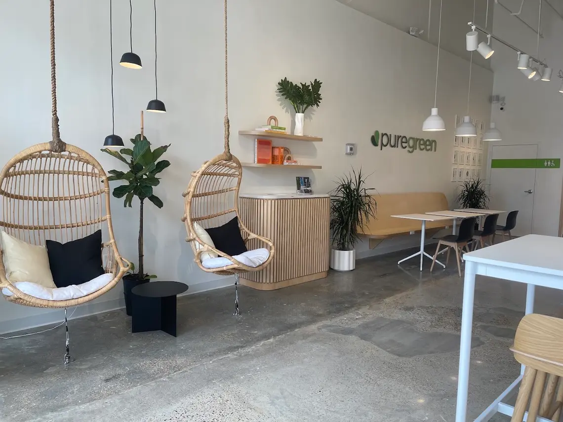 Hanging rattan chairs and bench seating inside Pure Green West University
