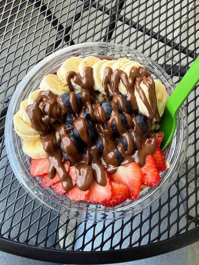 An acai bowl with banana, berries and chocolate drizzle at Pure Green West University